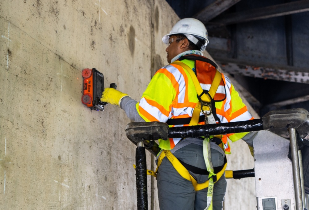 Person holding a GPR device vertically on a concrete wall